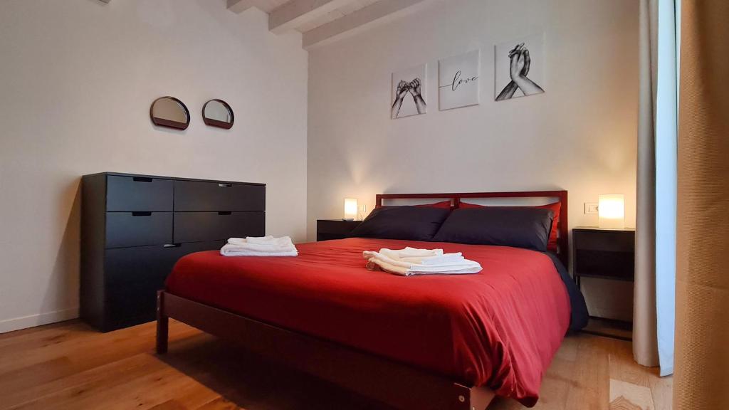 een slaapkamer met een rood bed en handdoeken erop bij PORTA NUOVA - Casa Vacanze Ai Mille - 3 in Bergamo