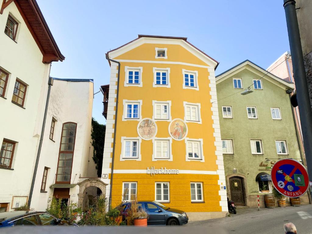 żółty budynek w środku dwóch budynków w obiekcie Blackhome Vintage Innsbruck City Centre I contactless check-in w mieście Innsbruck