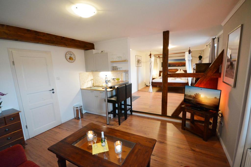 a living room with a table and a kitchen and a room at Sieben-Berge-Haus in Brüggen