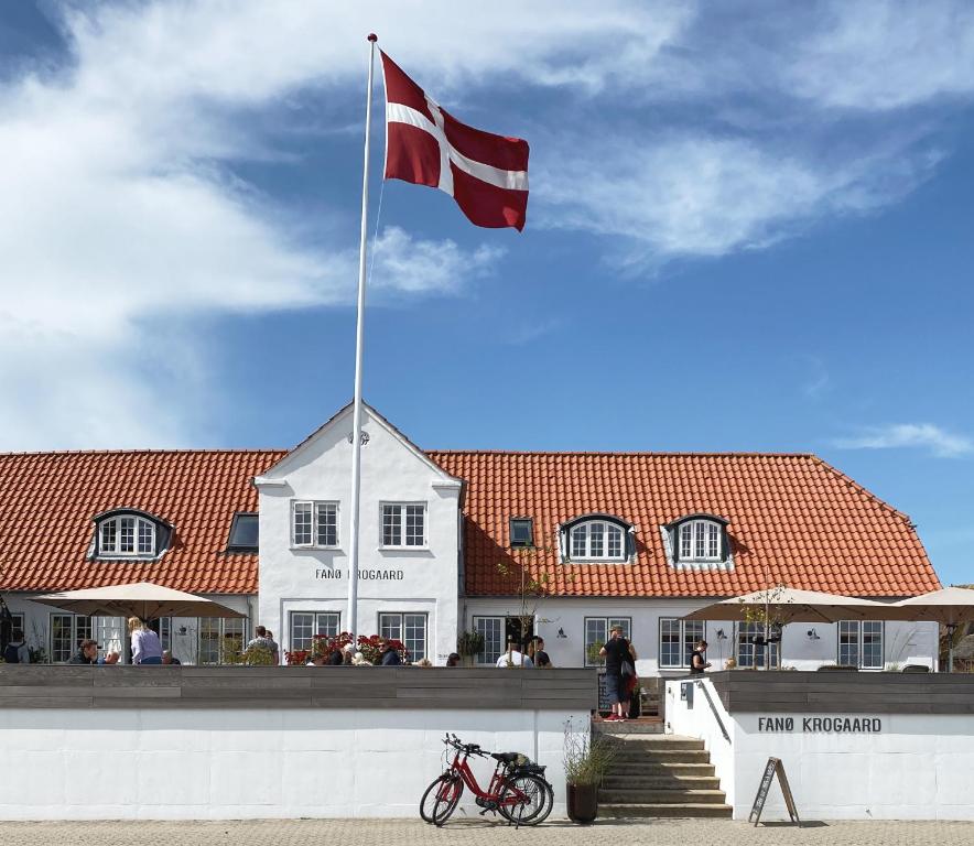 uma bandeira num poste em frente a um edifício em Fanø Krogaard em Fanø