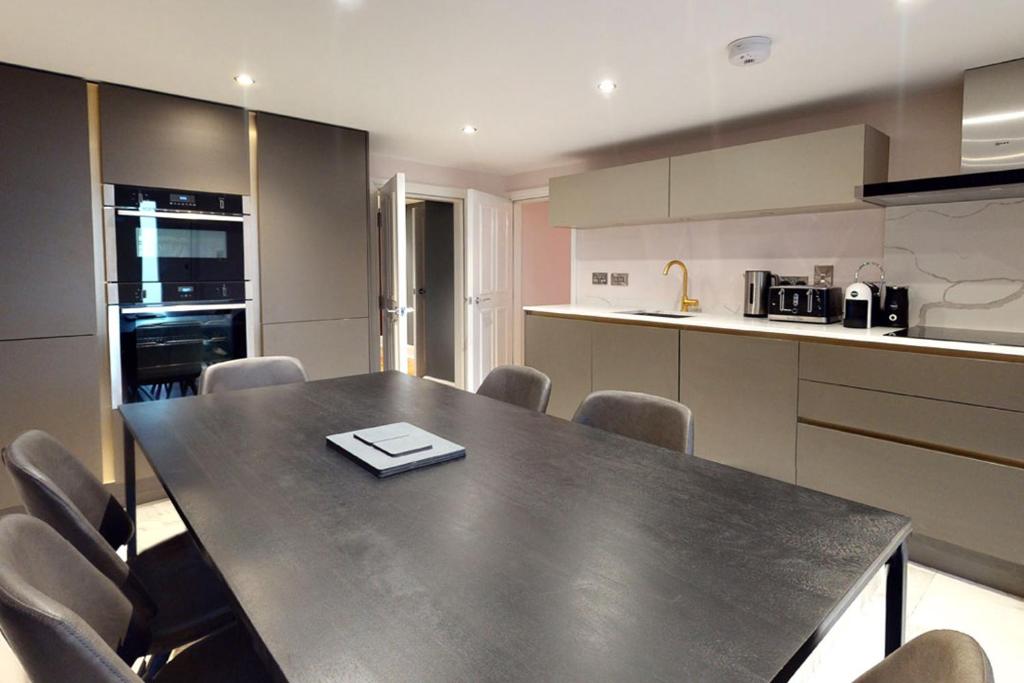 a kitchen with a table and chairs in a room at The Nook at Nydsley Hall - Featuring Patio & Hot tub in Pateley Bridge