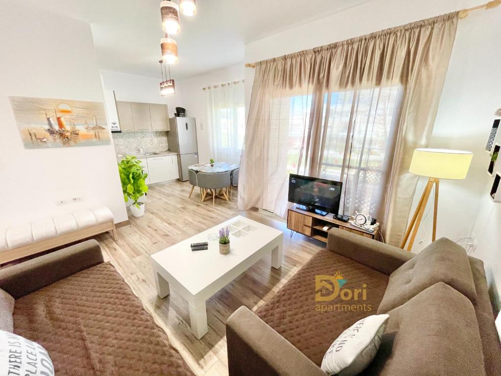 een woonkamer met een bank en een tafel bij Dori Apartments Perla Resort in Durrës