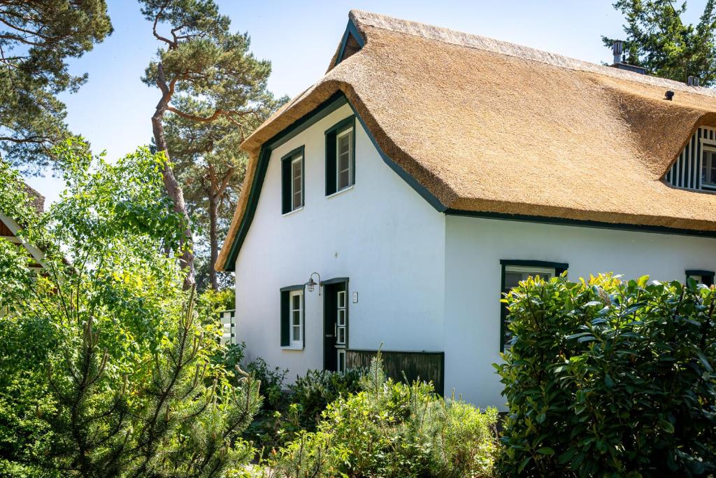 a white house with a thatched roof at Strandhaus Düne 19 - Freude in Neuhaus