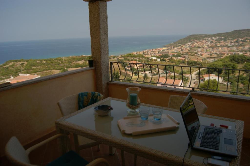 mesa con ordenador portátil en la parte superior de un balcón en Casa Elicriso, en Castelsardo