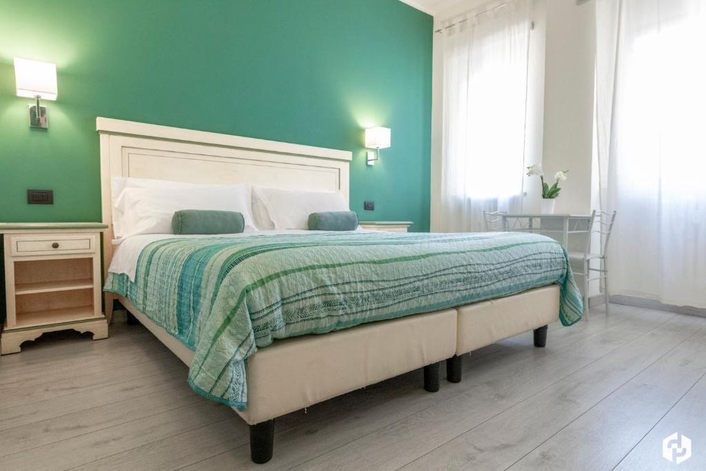 1 dormitorio con 1 cama grande y pared verde en Daydreaming House, en Verona