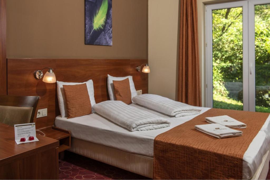 Posteľ alebo postele v izbe v ubytovaní Patak Park Hotel Visegrád