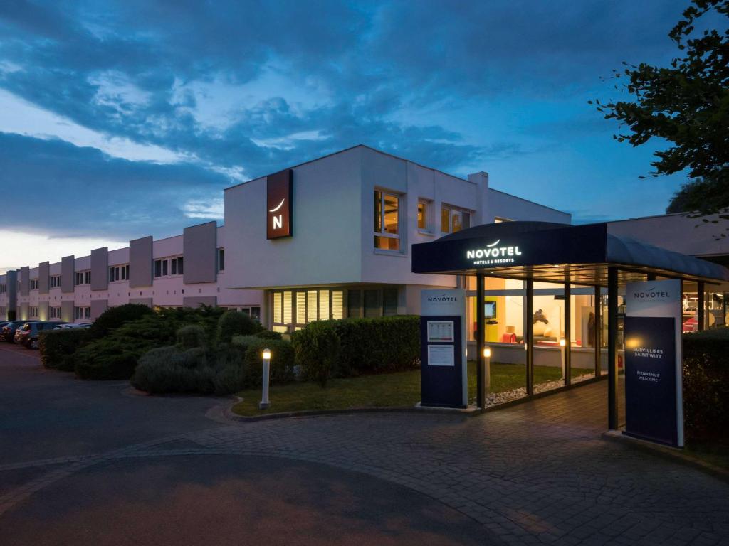 un bâtiment avec un magasin devant lui dans l'établissement Novotel Roissy Saint Witz, à Saint-Witz