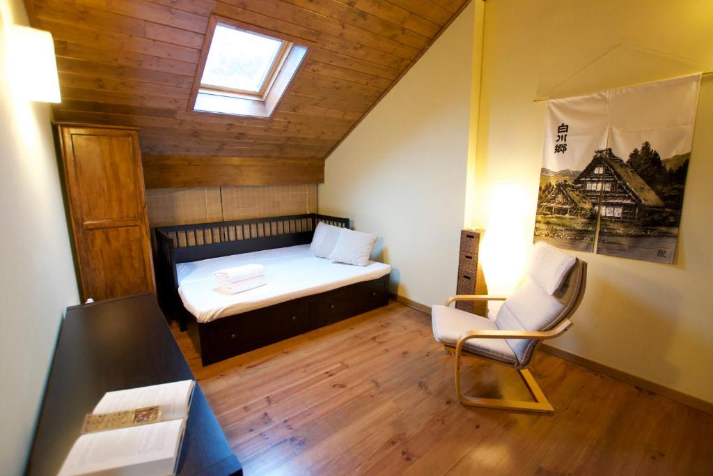 a small room with a bed and a chair at Duplex el Pla de la Tour in Latour-de-Carol