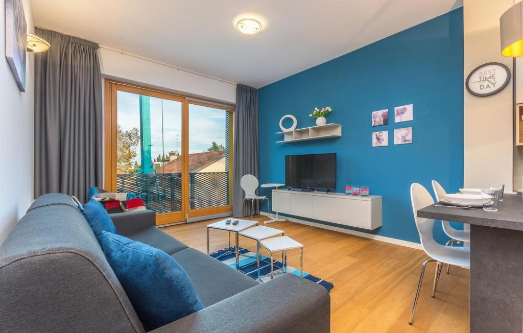 een blauwe woonkamer met een blauwe muur bij Appartments Strawberry in Novigrad Istria