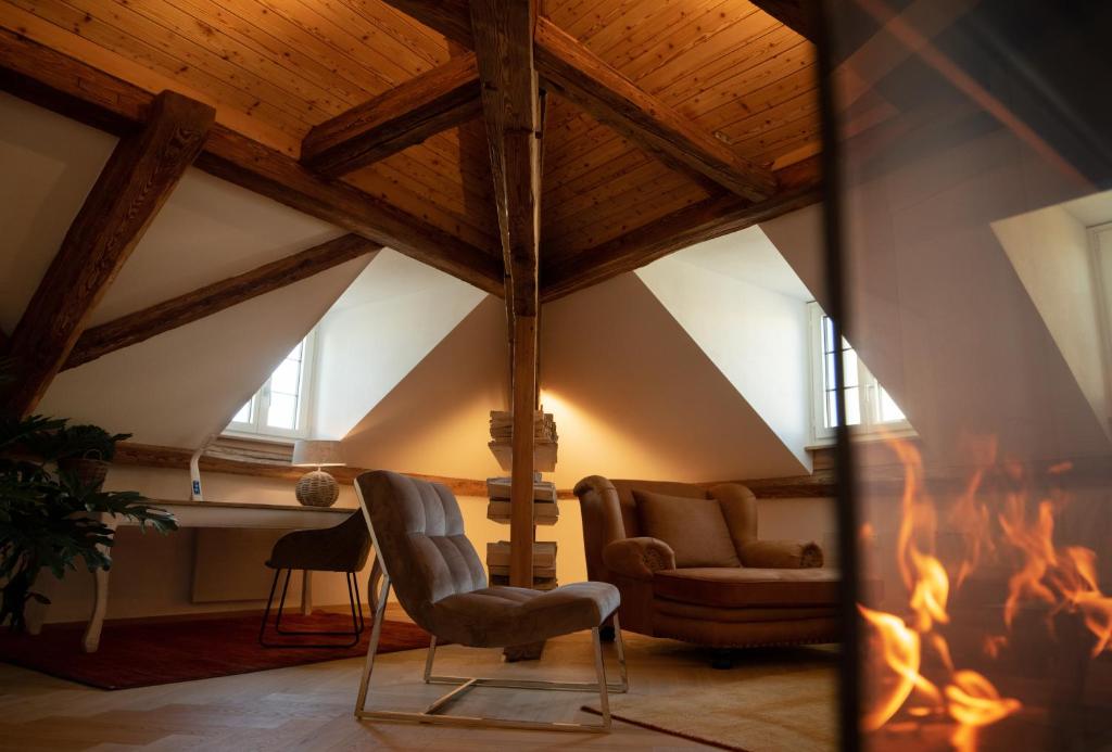 a living room with a fireplace and a chair at Moderne Altbauwohnung mit Pool und Sauna in Bern
