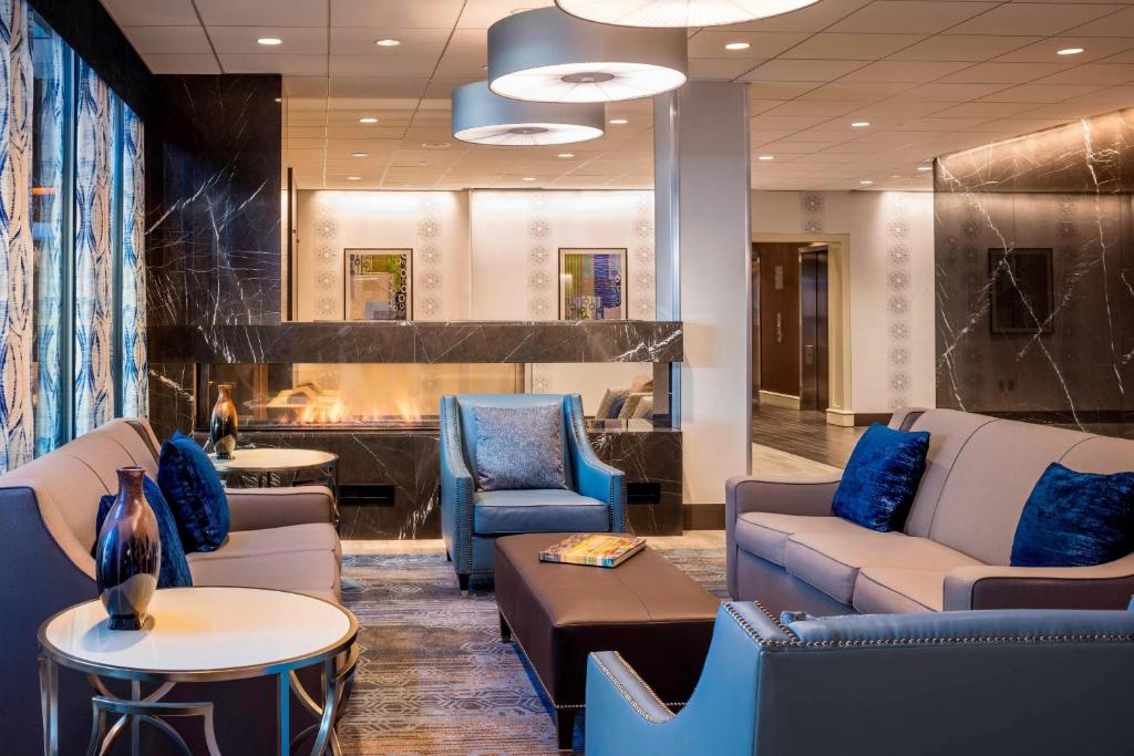 una sala d'attesa con divani, sedie e tavoli di Four Points by Sheraton Norwood Conference Center a Norwood