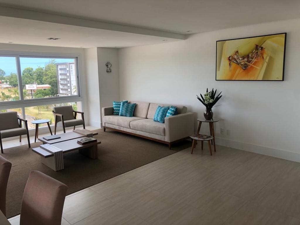 a living room with a couch and a table at Atlântida Green Square - 606B in Xangri-lá