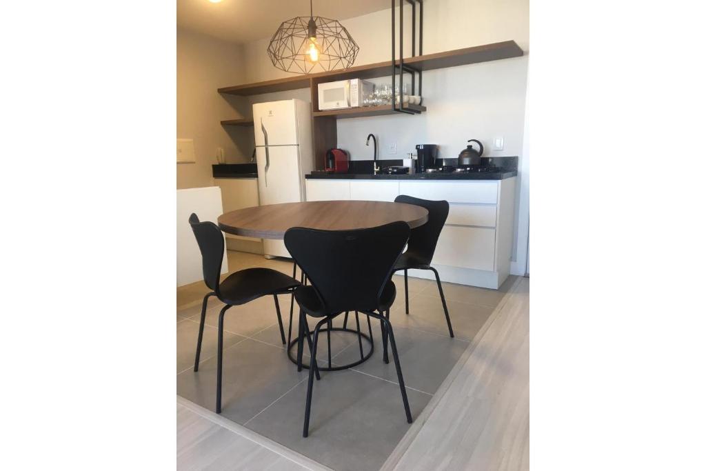 a kitchen with a table and chairs in a room at Paseo Del Molino - 704 in Caxias do Sul