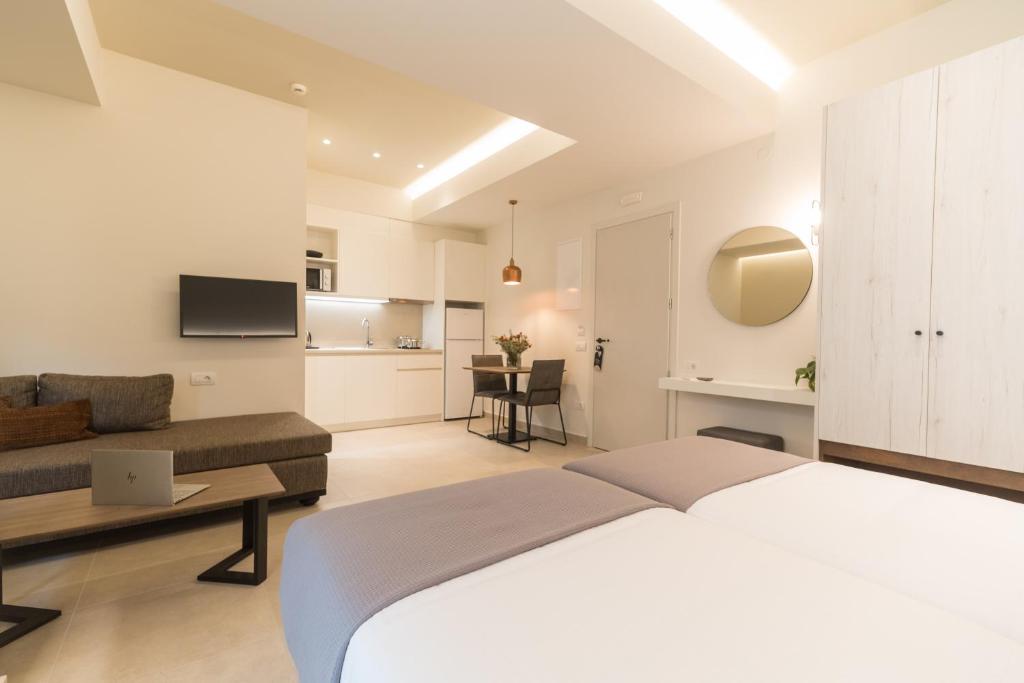 a bedroom with a large bed and a living room at ANTEL Suites & Apartments in Chania