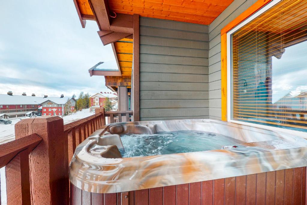 a hot tub on the deck of a house at Bears Paw 5 in Big White