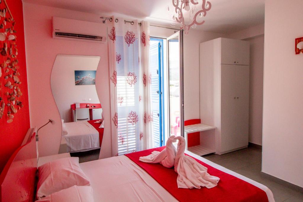 a bedroom with a bed with red and white at B&B Aria di Mare in San Vito lo Capo