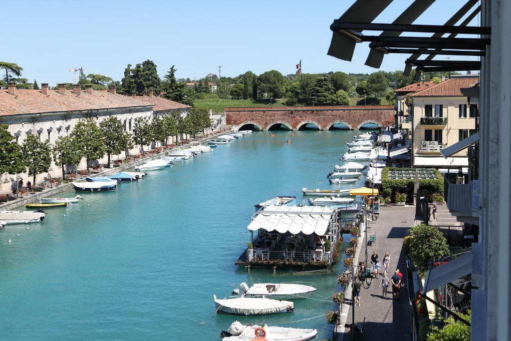 a group of boats are docked on a river at Hotel Bell'arrivo by Dori in Peschiera del Garda