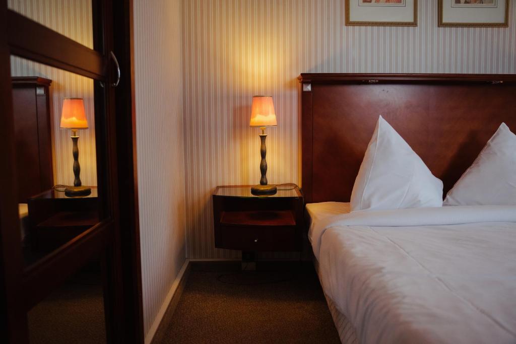 een hotelkamer met een bed en twee lampen op tafels bij B-aparthotel Ambiorix in Brussel
