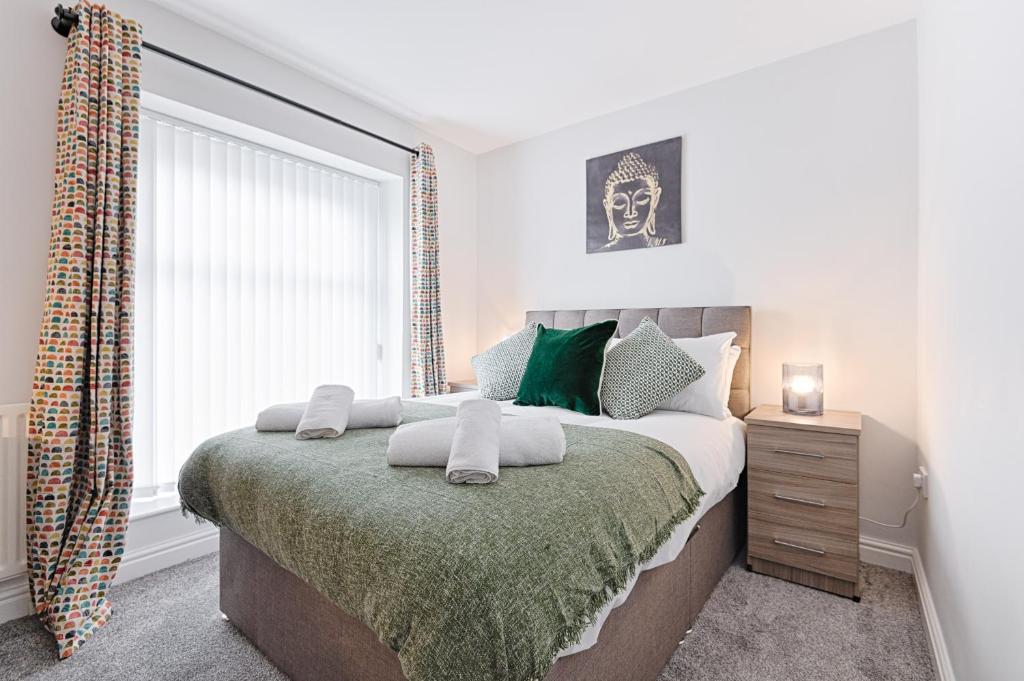 a bedroom with a large bed and a window at Alma Accommodation - TV in Every Bedroom! in Swansea