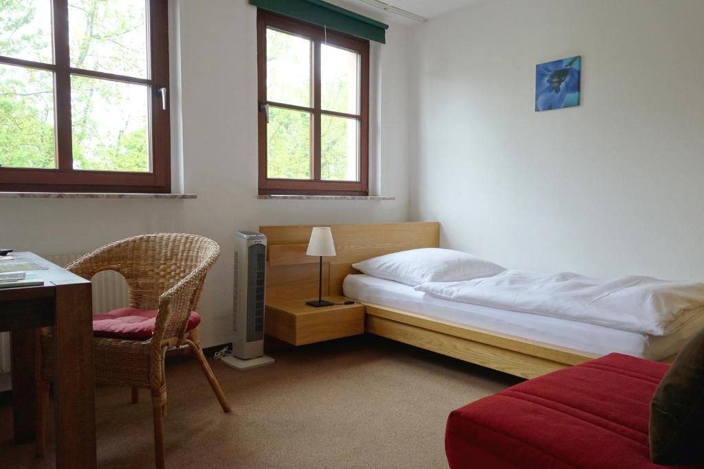 a bedroom with a bed and a desk and a chair at Pension am Helenenwall in Cologne
