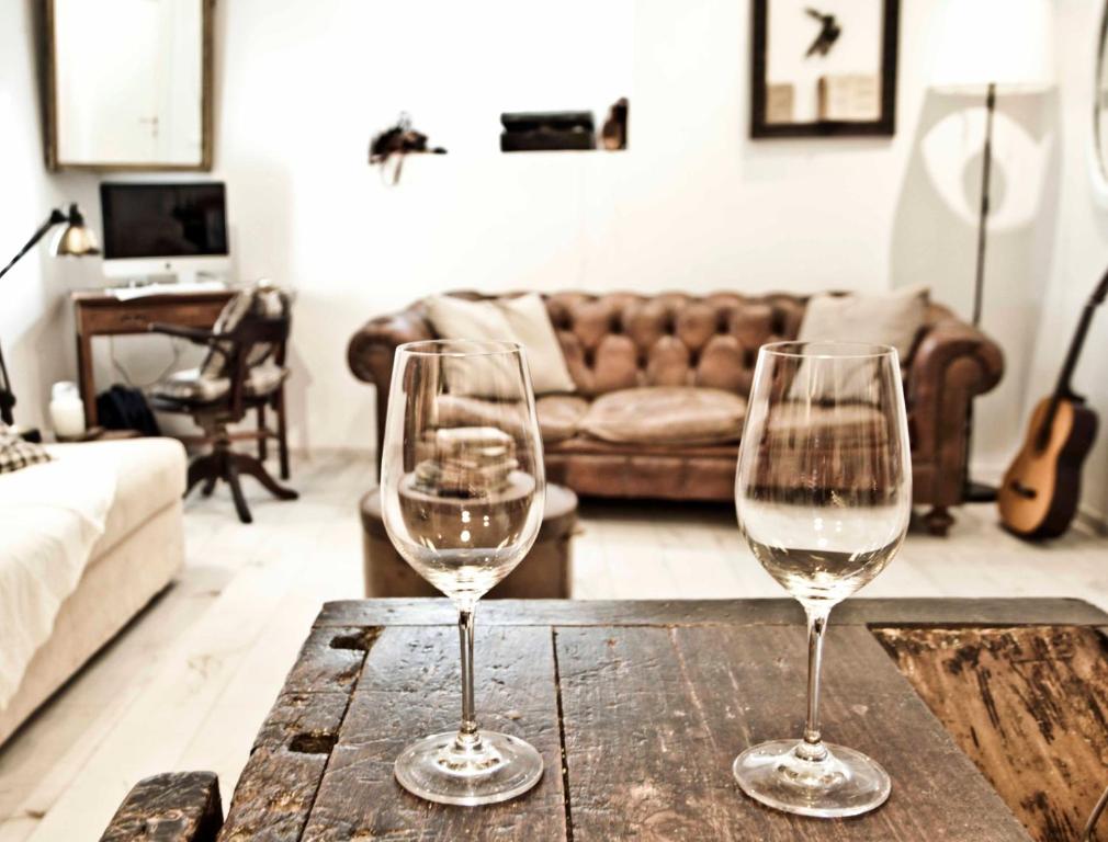 two wine glasses sitting on a wooden table in a living room at SottosopraSannio in Rome