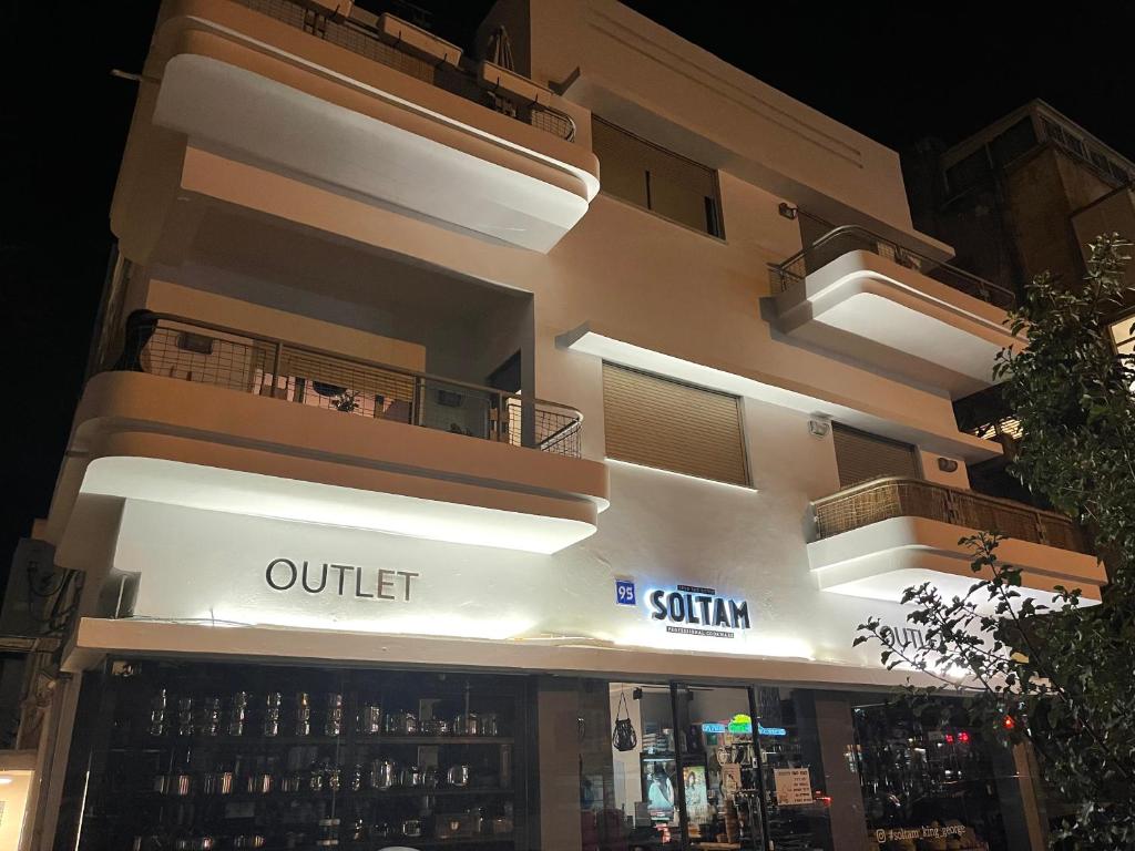 a lit up building with a store front at night at Roza Apartment in Tel Aviv