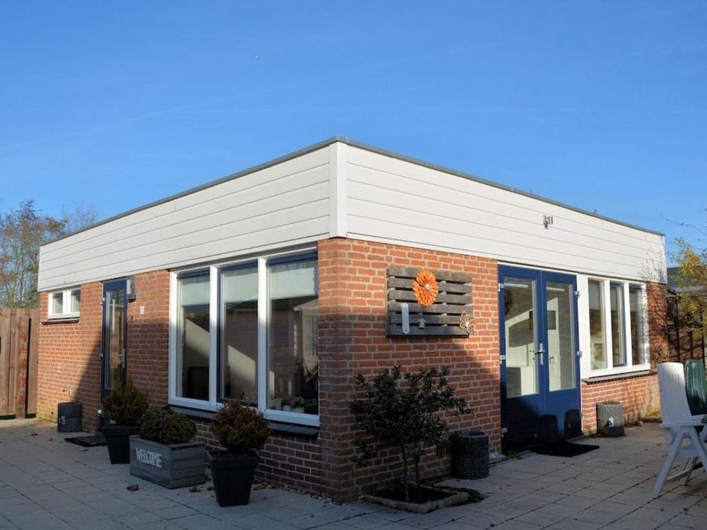 ein Backsteingebäude mit großen Fenstern darauf in der Unterkunft Duinnest in Noordwijkerhout