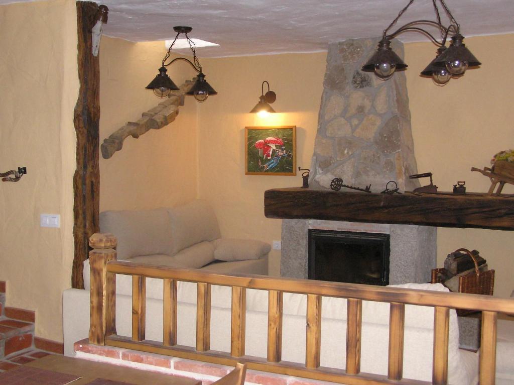 a living room with a couch and a fireplace at Hostal Rural Las Cuatro Calles in San Martín del Pimpollar