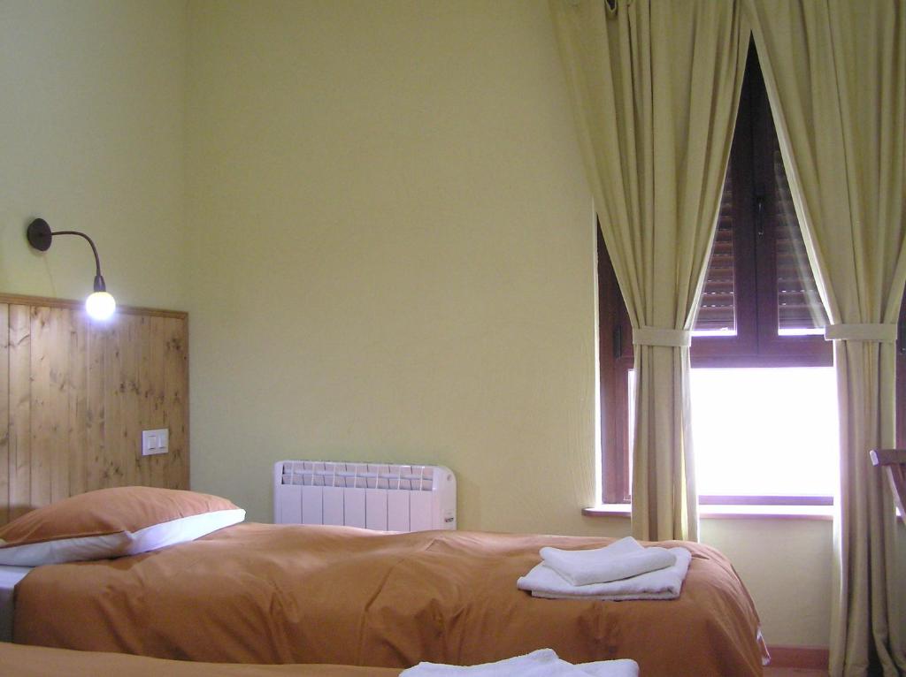 A bed or beds in a room at Hostal Rural Las Cuatro Calles