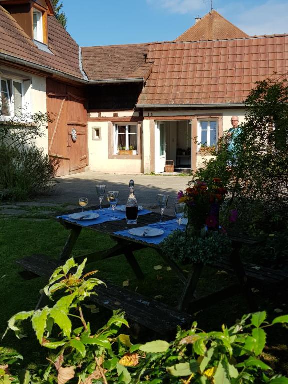 a table with a bottle of wine on it in a yard at Le Petit Studio in Cosswiller