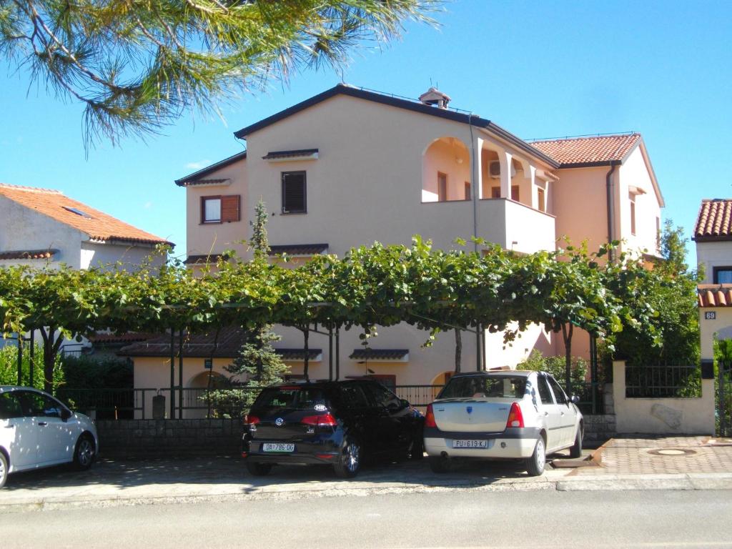 a house with cars parked in front of it at Apartments Neda - Poreč South in Poreč