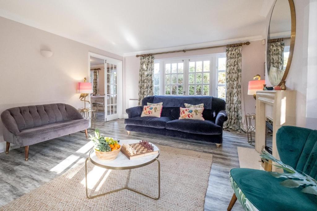 a living room with a blue couch and a table at 1 Sanctuary Court - Aldeburgh Coastal Cottages in Thorpeness