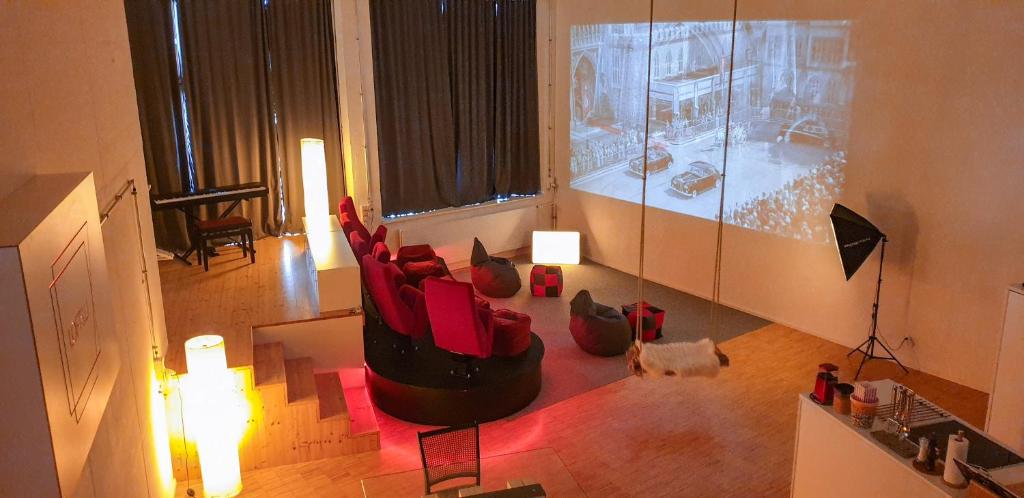 an image of a living room with red chairs at Loft with Home Cinema in Triesenberg
