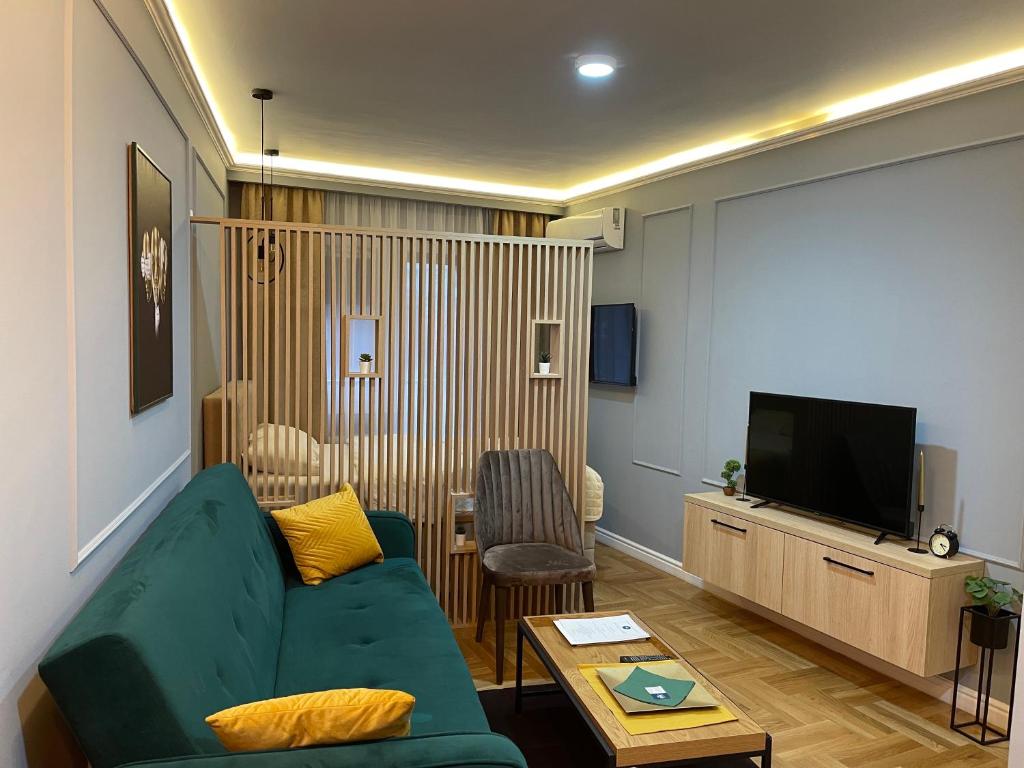 sala de estar con sofá verde y TV de pantalla plana en BW Luxury Apartment Bijeljina, en Bijeljina