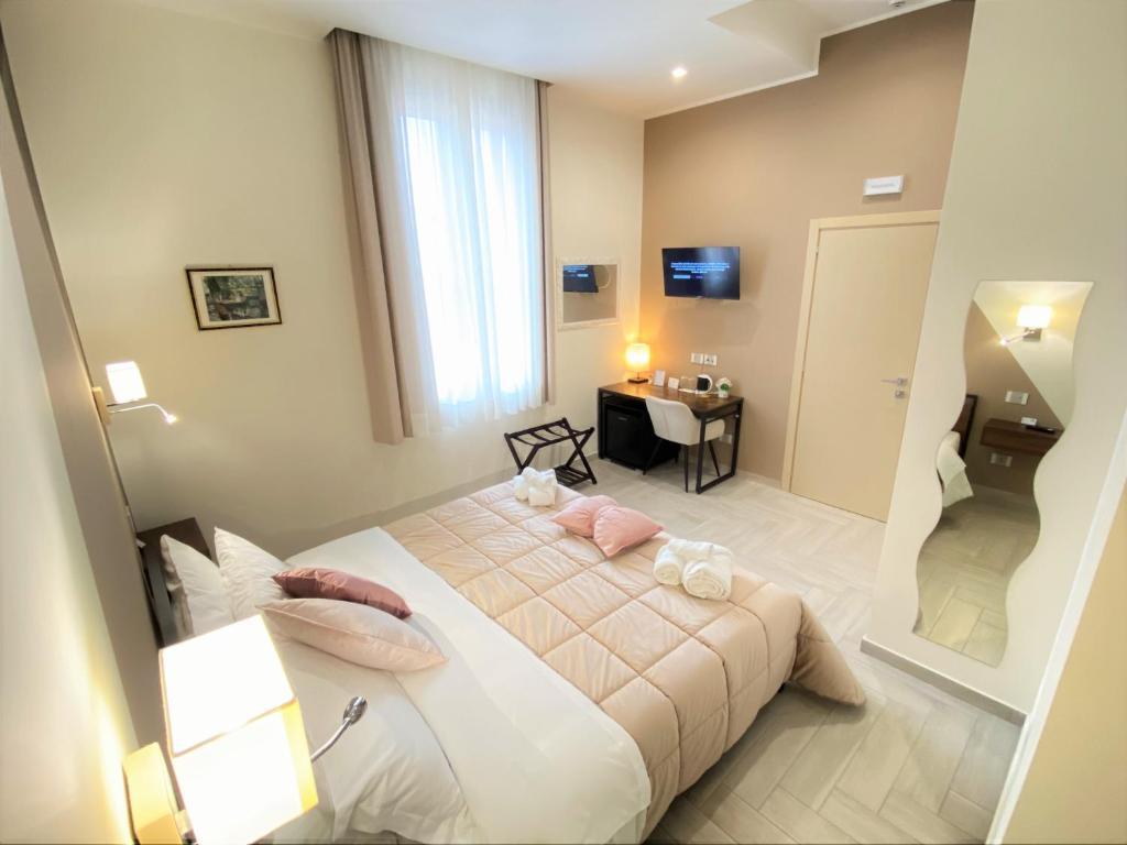 1 dormitorio con cama, mesa y espejo en B&B De Nava Suite, en Reggio Calabria