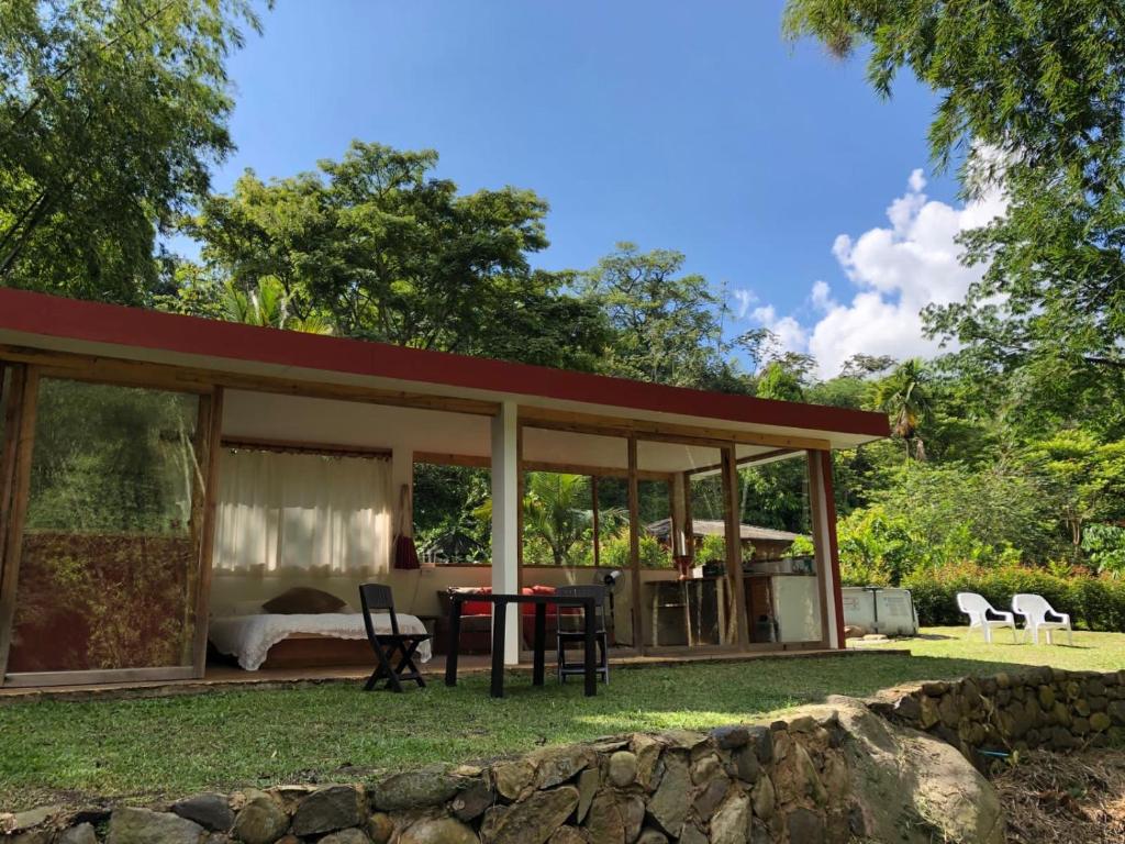a guest house with a bed and a table at No Sólo Río in La Vega