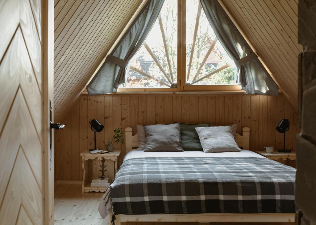 Ce lit se trouve dans un dortoir doté d'une fenêtre. dans l'établissement Domek Pod Lipkami, à Zakopane