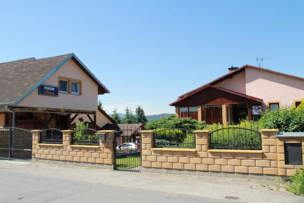 una recinzione di mattoni di fronte a una casa di Penzion Ivana a Valašské Meziříčí