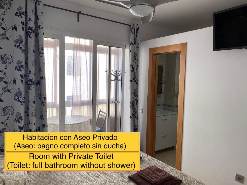 um quarto com uma porta de vidro deslizante com uma janela em Málaga Centro habitaciones privada en apartamento compartidos em Málaga
