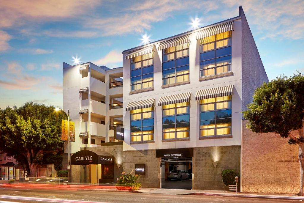 a large building on a city street with trees at Carlyle Inn in Los Angeles