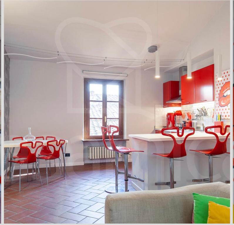 eine Küche mit roten Stühlen und einem Tisch im Zimmer in der Unterkunft L'angelo in cornice apartment with Wifi and AC in Lucca