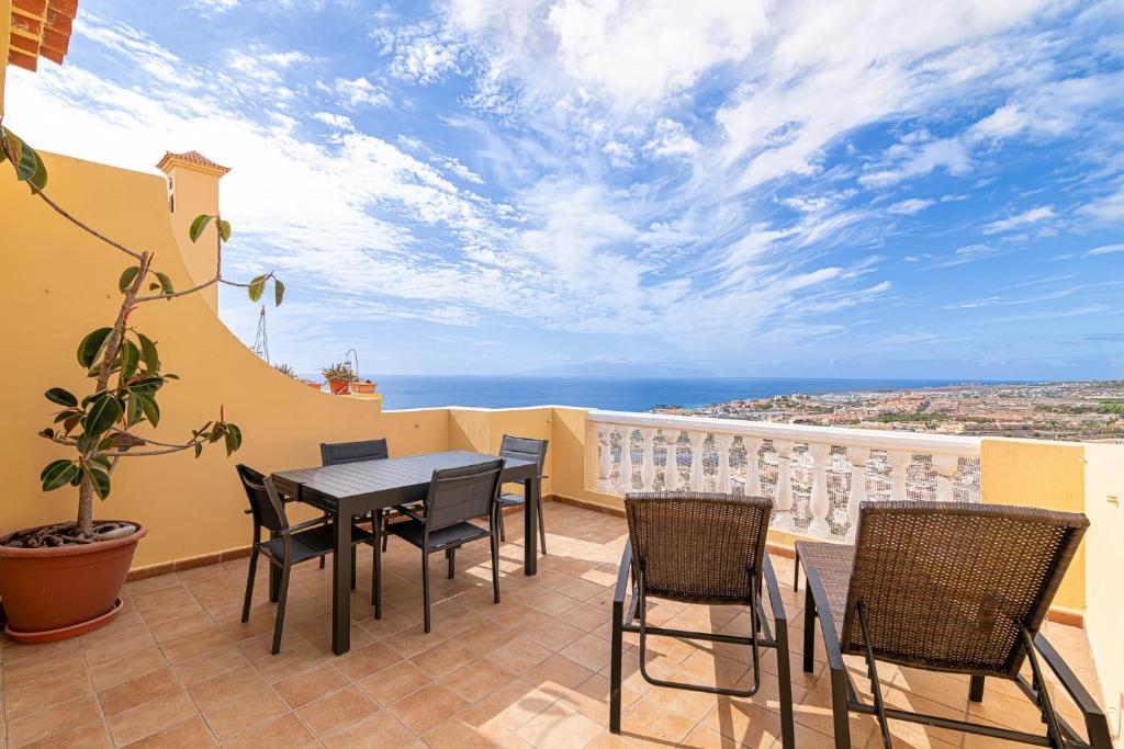 een patio met een tafel en stoelen op een balkon bij Top floor with ocean view in Adeje