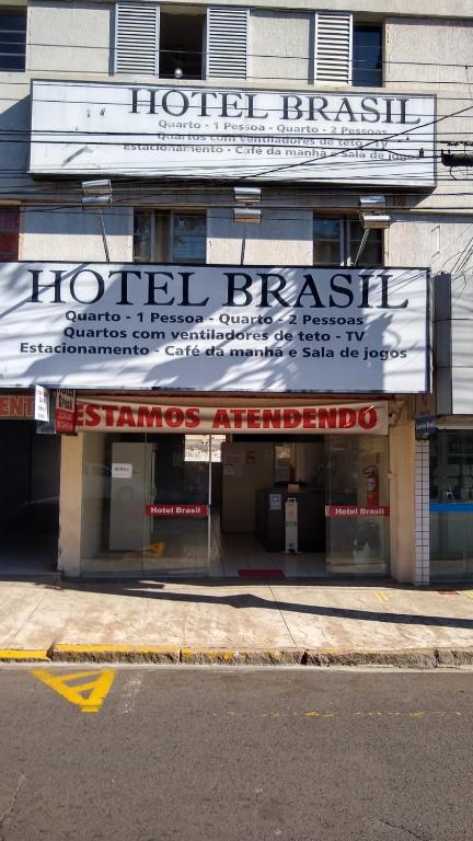 a building with a sign for a hotel pharmacy at Hotel Brasil in Presidente Prudente