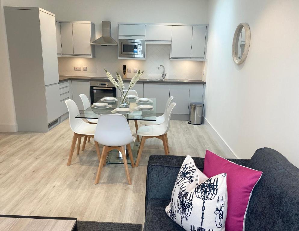 a kitchen and dining room with a table and chairs at Fleet Heights Apartment Four in Fleet