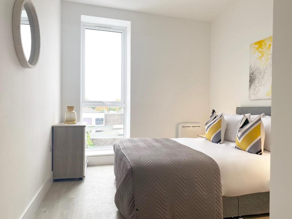 a white bedroom with a large bed and a window at Skyline at Fleet Heights Apartment Six in Fleet