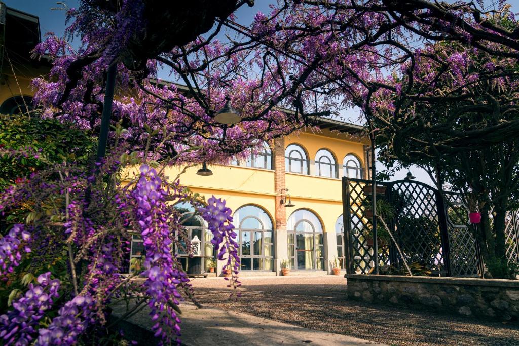 een gebouw met paarse bloemen ervoor bij il Glicine B&B RISTORANTE in Cazzago San Martino