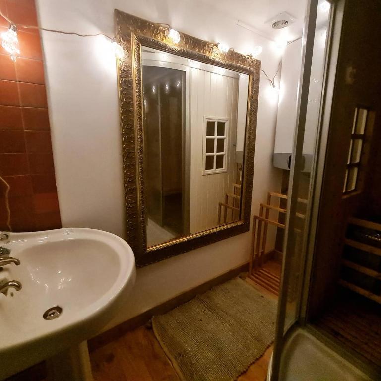 a bathroom with a sink and a mirror on the wall at Le monde d&#39;Echozellia in Saint-Germain-des-Champs