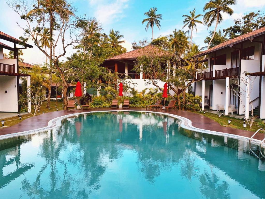 una piscina frente a un complejo en Palm Garden Ayurveda Resort en Ahangama