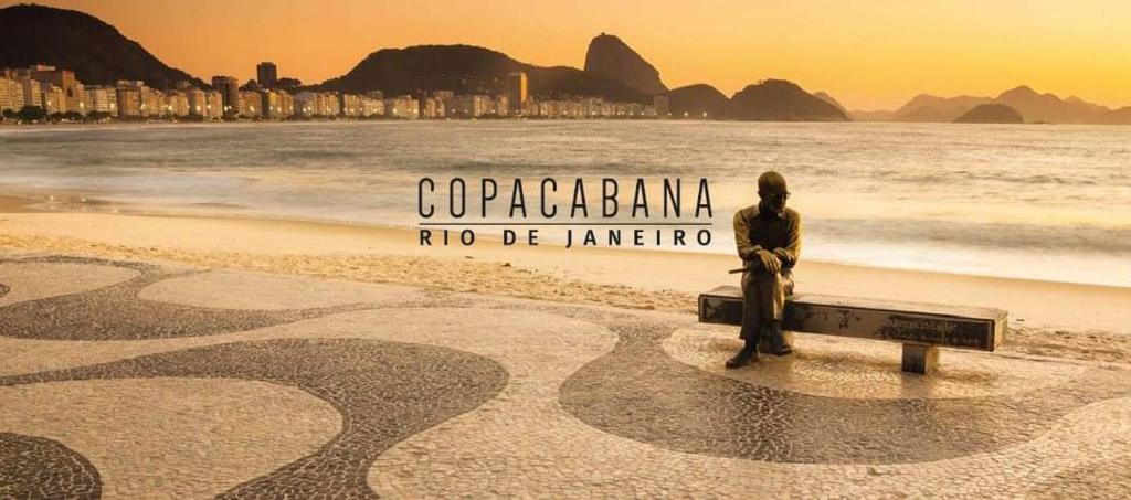 a man standing on a bench on the beach at Copacabana Praia Rio in Rio de Janeiro