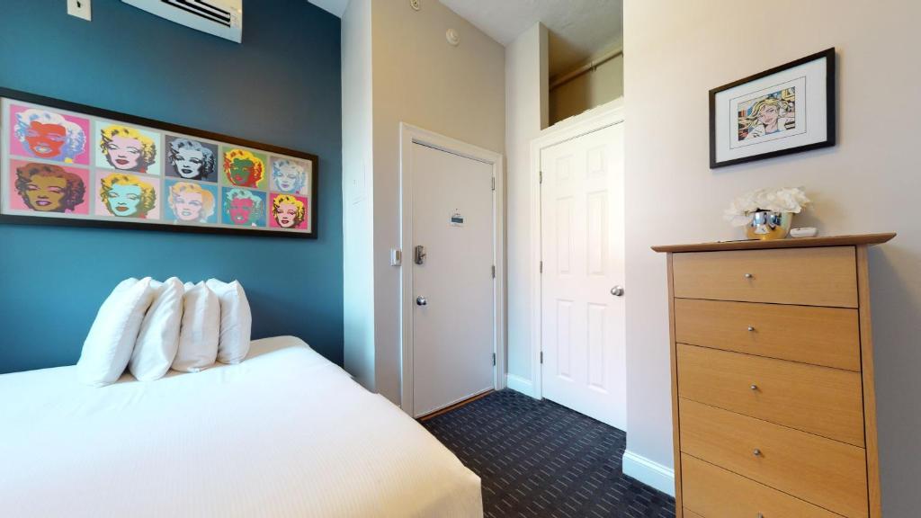 um quarto com uma cama branca e uma parede azul em South End Studio Perfect for Work Travel #26 em Boston